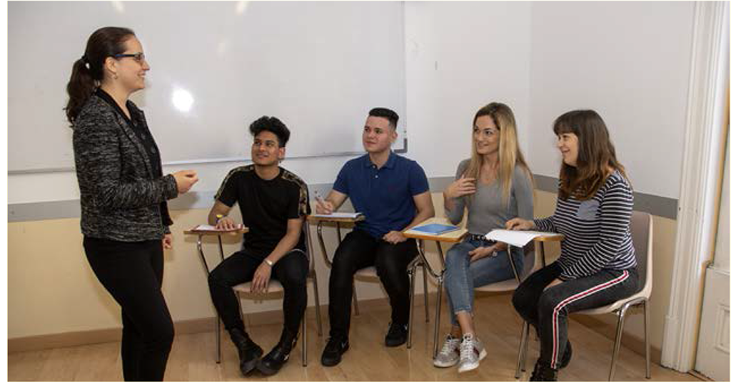 A professor talks to her students on the first day of class.